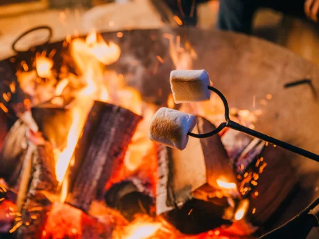 Marshmallows being toasted over a campfire outdoors